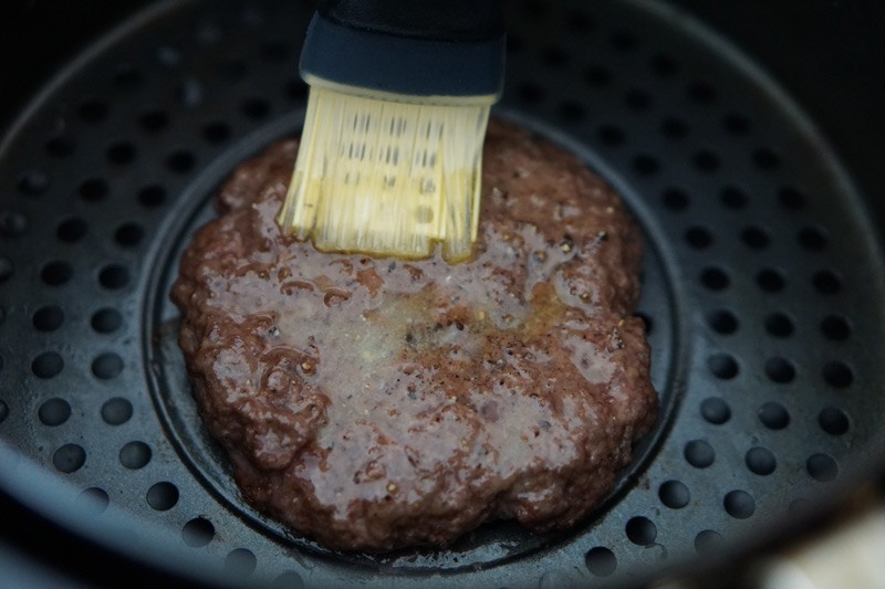 burger in air fryer being basted