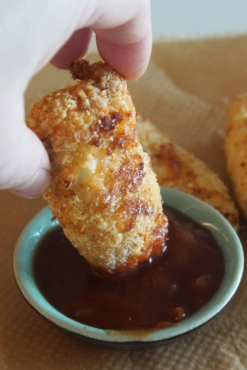 chicken tender being dipped in sauce