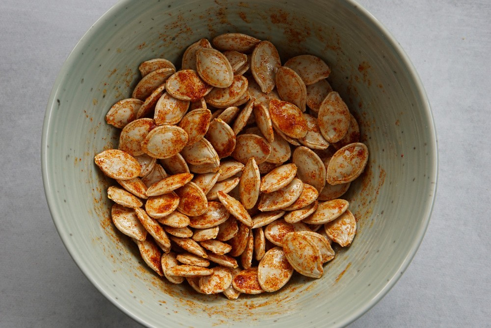 Seasoned raw pumpkin seeds in a bowl