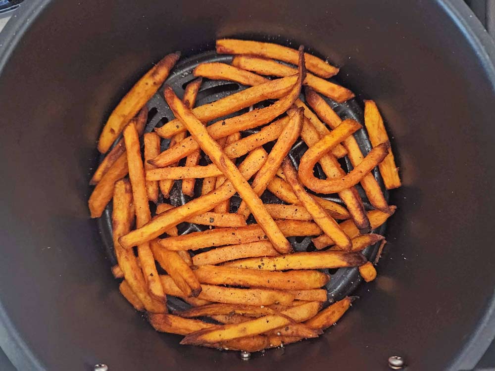Cooked sweet potato fries in the air fryer basket